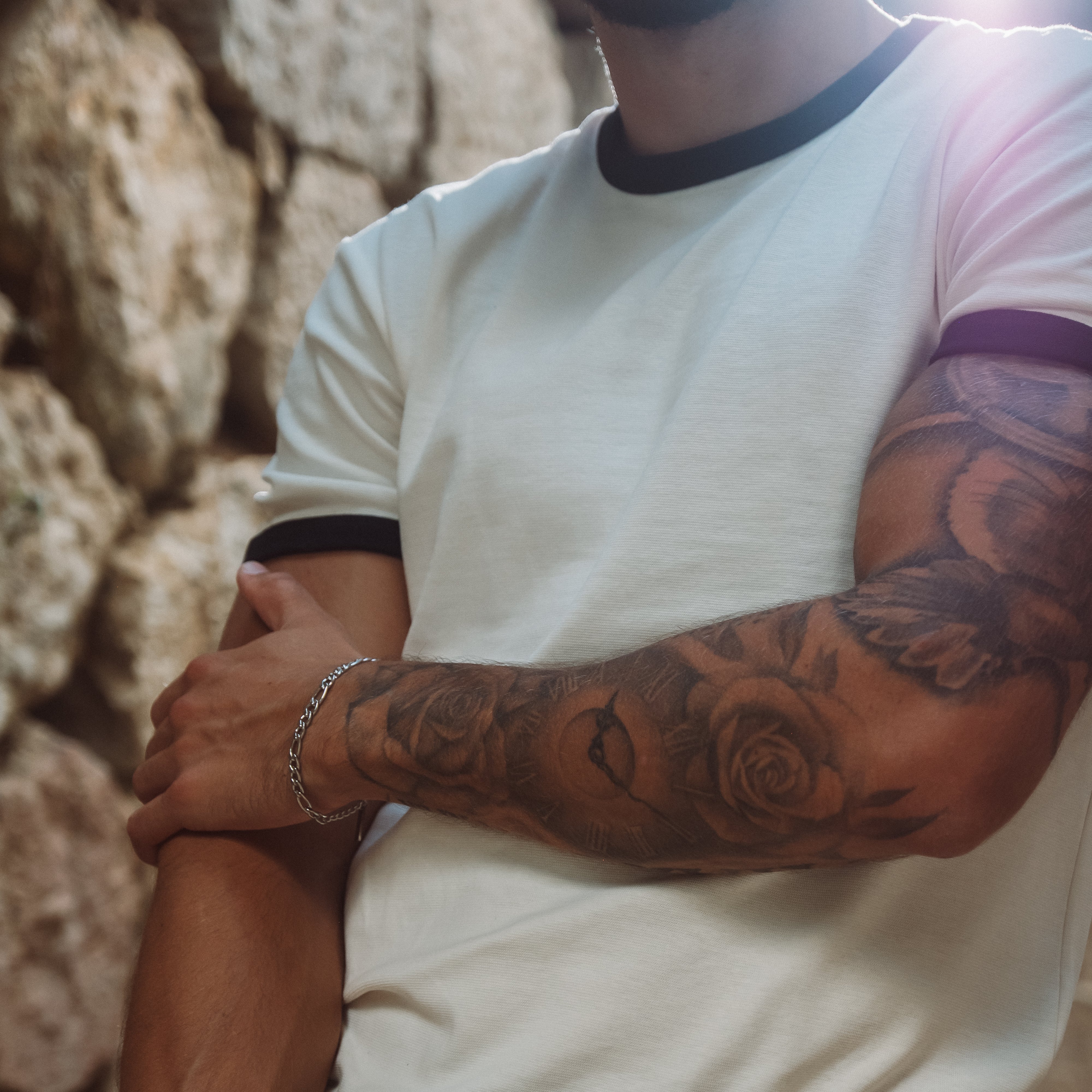 Tatoveret arm med sølvfarvet Michigan armbånd fra Fadeless