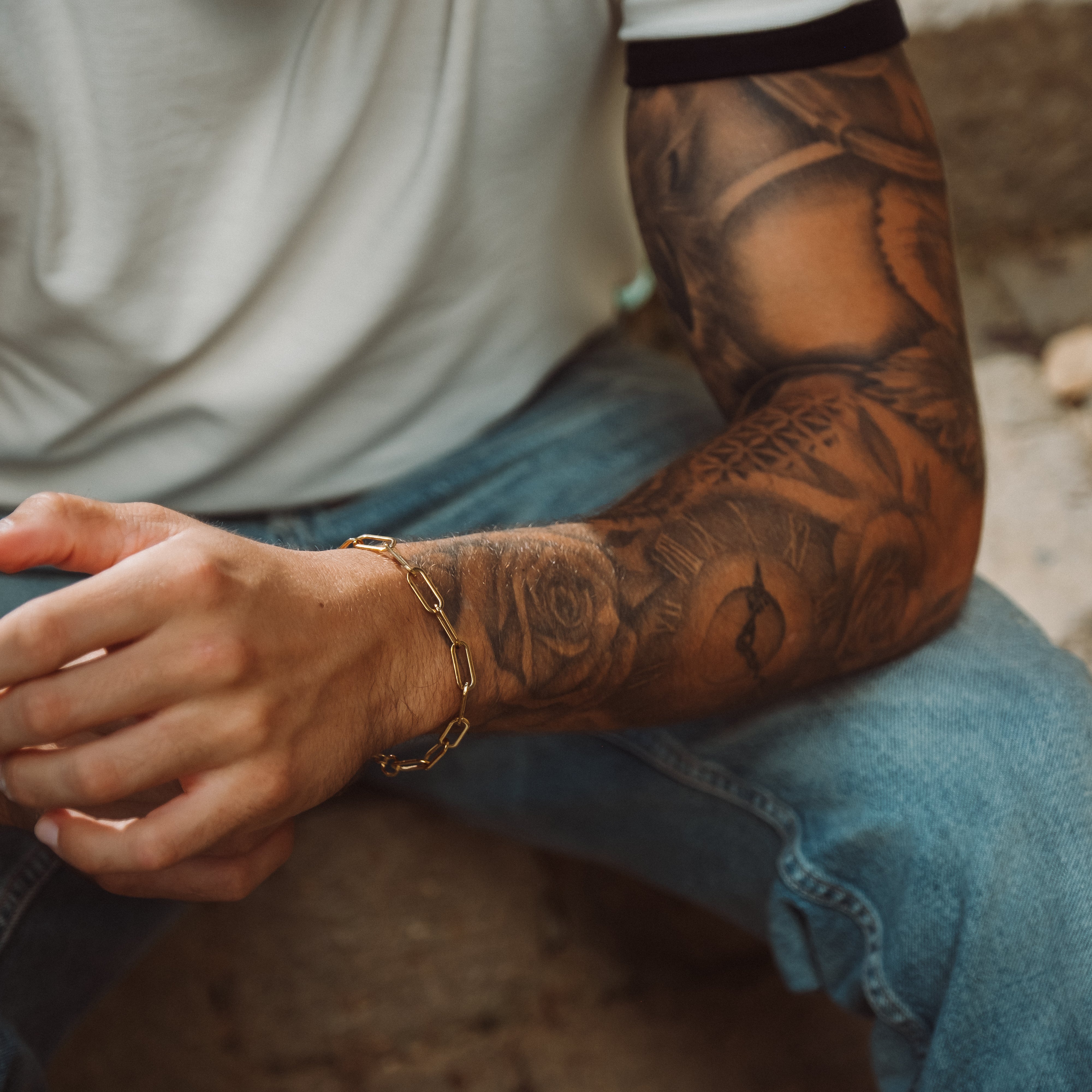 Guldbelagt lænkearmbånd på tatoveret håndled