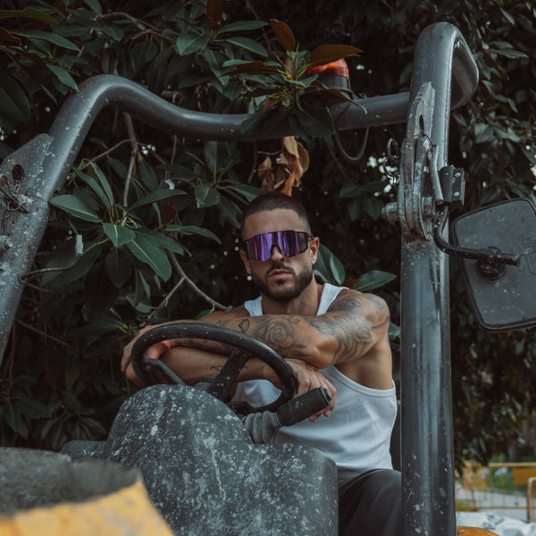 Mand på cykel med Noire Grape sportsbriller i lilla med spejlglas