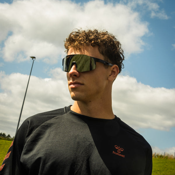 Mand med grå sportsbriller fra Atlithé under blå himmel