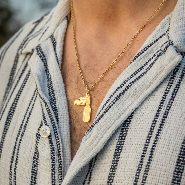 Guldbelagt halskæde med molotov-vedhæng på stribet skjorte