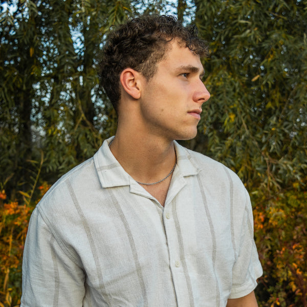 Mand bærer sølvfarvet rope chain halskæde udendørs