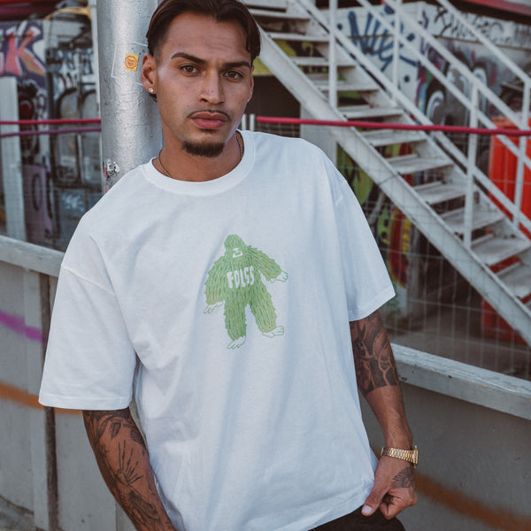 Mand iført hvid oversized Ray Tee med grønt monster print fra Fadeless