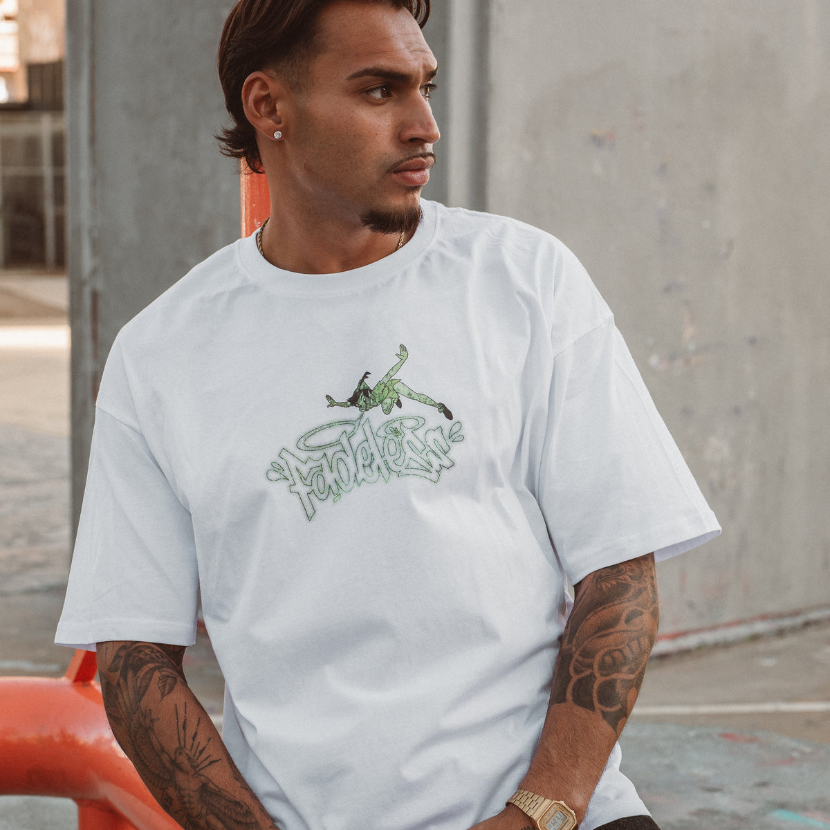 Mand iført hvid oversized boxfit t-shirt med grønt grafisk print fra Fadeless