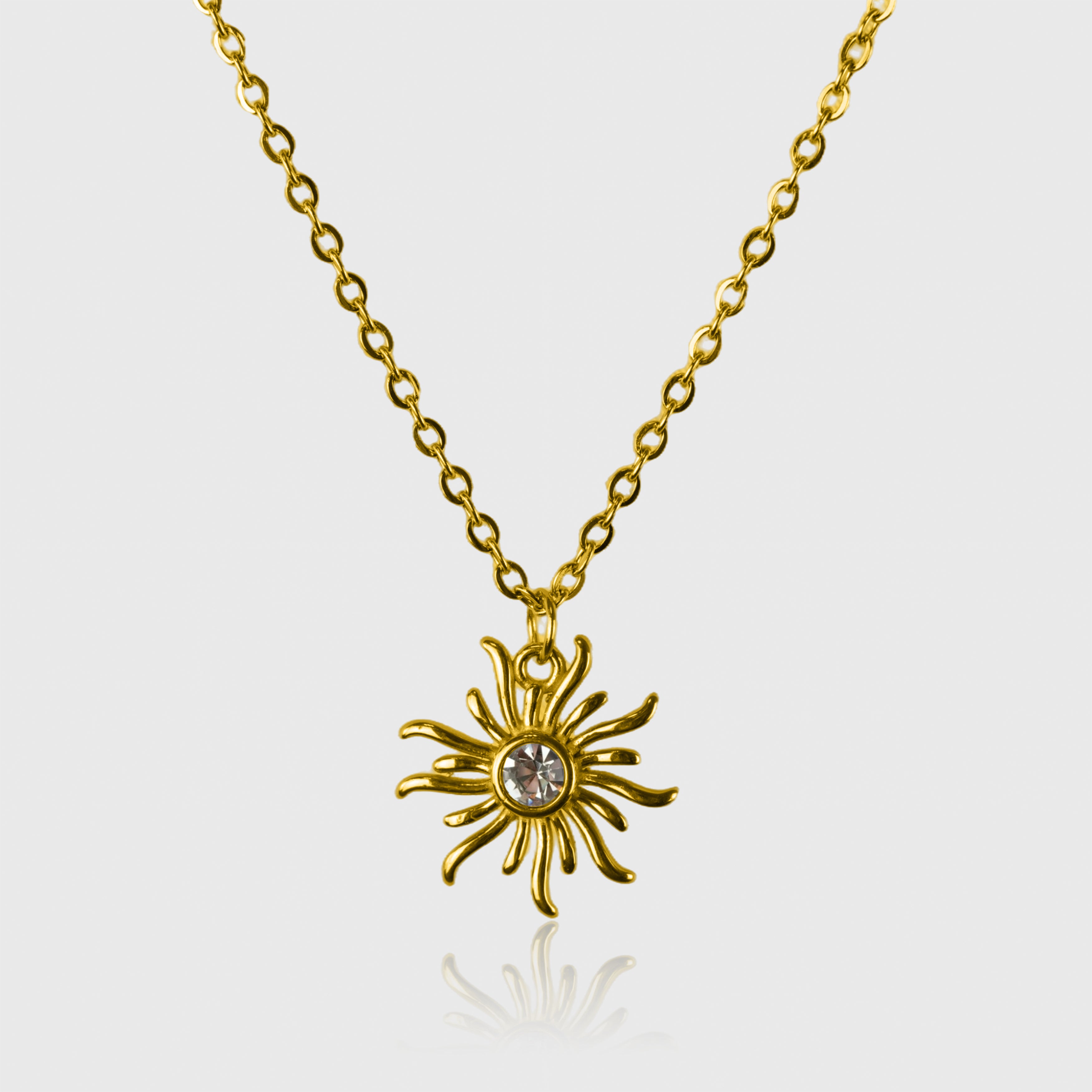 Guldfarvet halskæde med solformet vedhæng og krystal