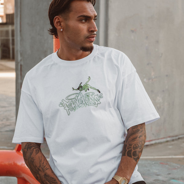 Mand iført hvid oversized boxfit t-shirt med grønt grafisk print fra Fadeless